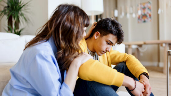 Worried son talking about school bullying with his mother